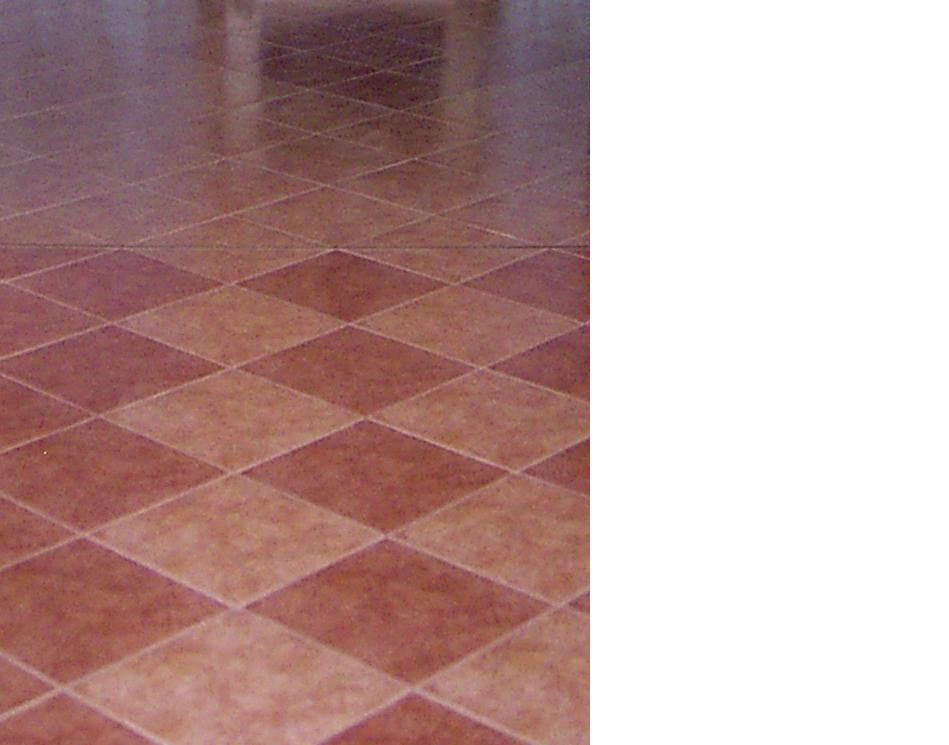 Ułożona pod kątem podłoga z płytek w odcieniach brązu i beżu, tworząca wzór rombów.